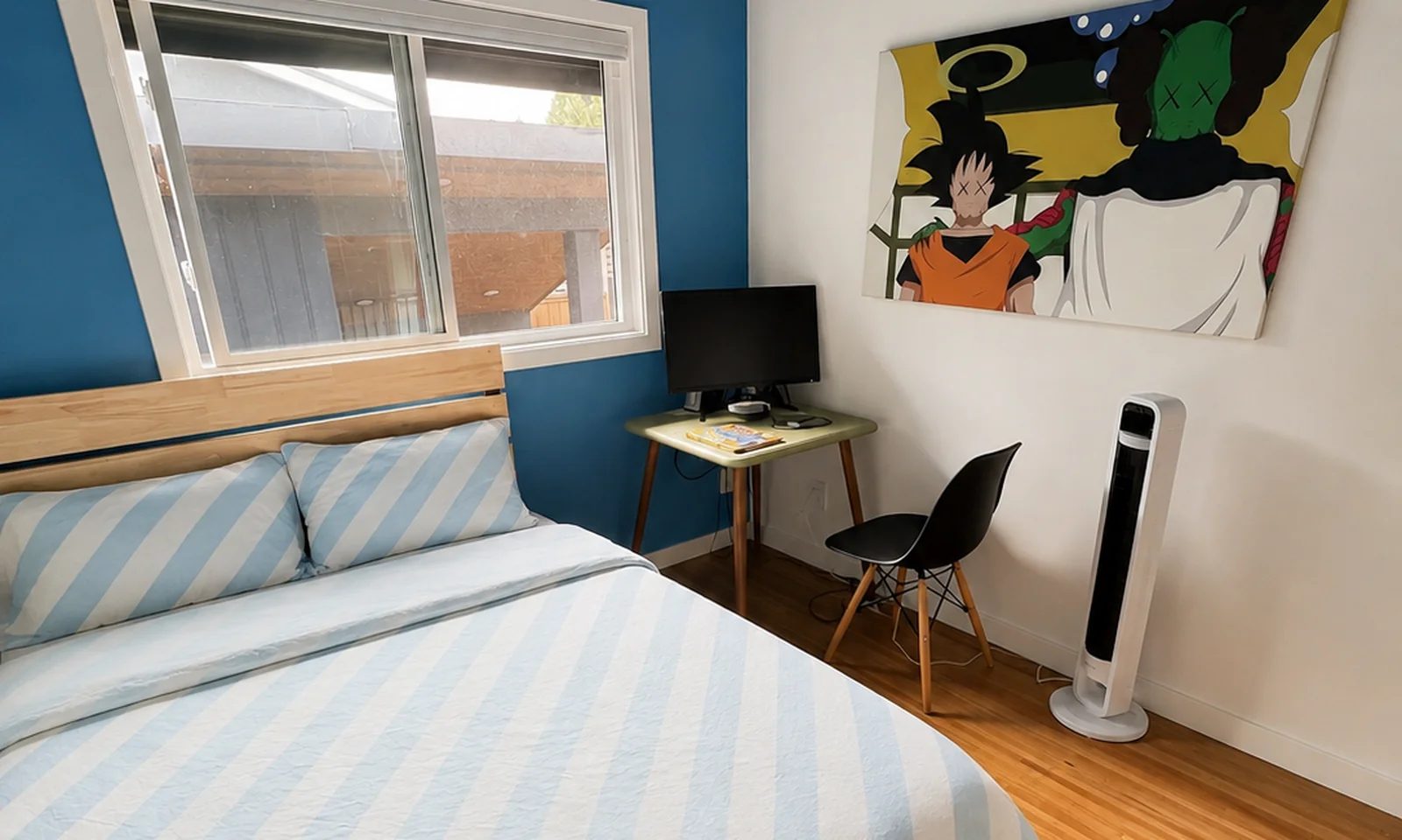 Second bedroom with a double bed, a small desk with a monitor, and a chair