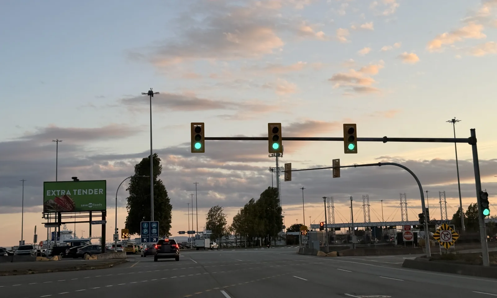 The last traffic lights before Tsawwassen Ferry Terminal, with the Drop-off / Parking and Vehicle Ticketing sign and the booths ahead